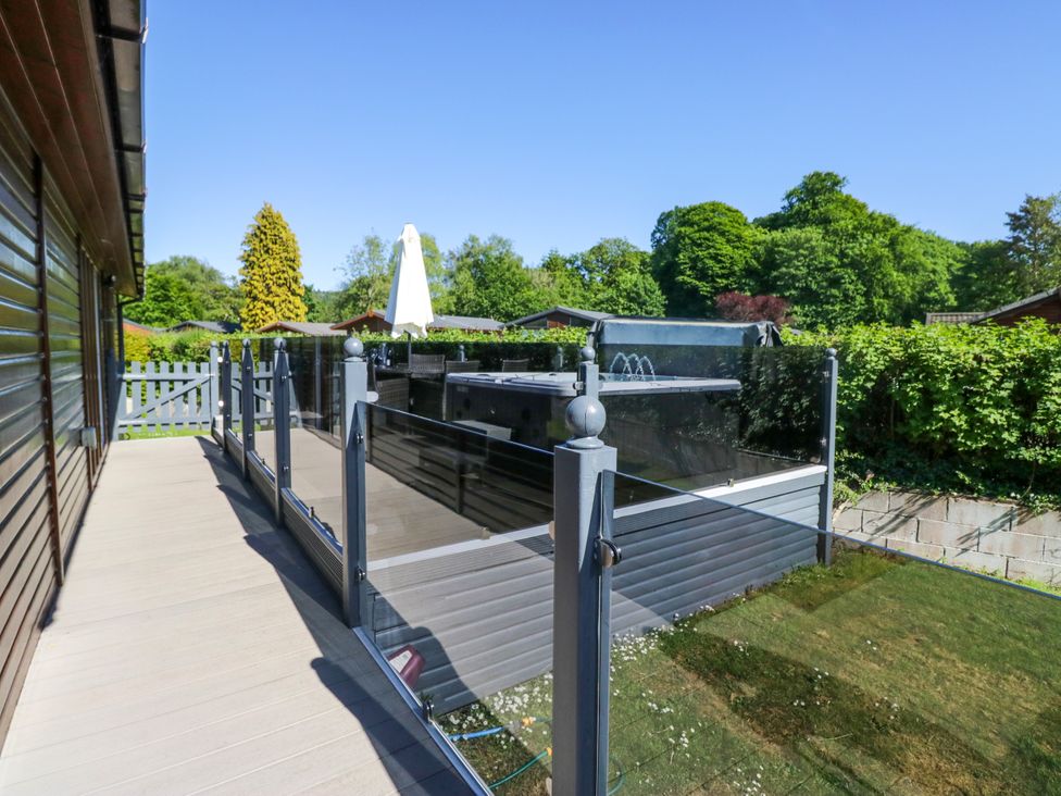An outdoor balcony with a hot tub at Dovedale Lodge in Troutbeck Bridge