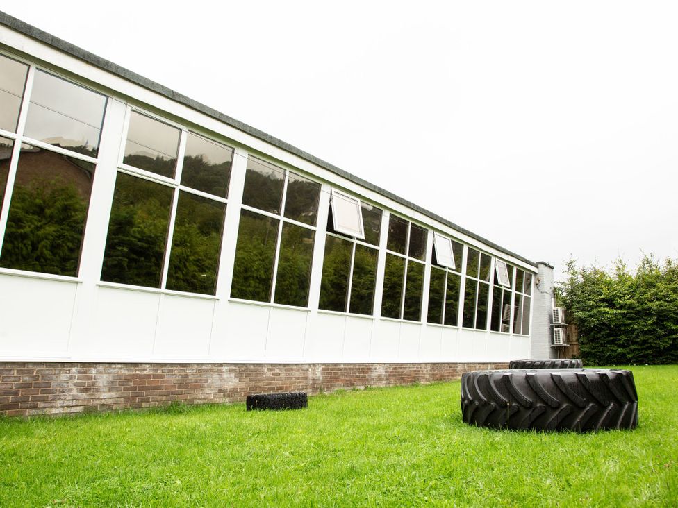 An outdoor area with a building and large tires at Dovedale Lodge White Cross Bay Holiday Park near Troutbeck Bridge