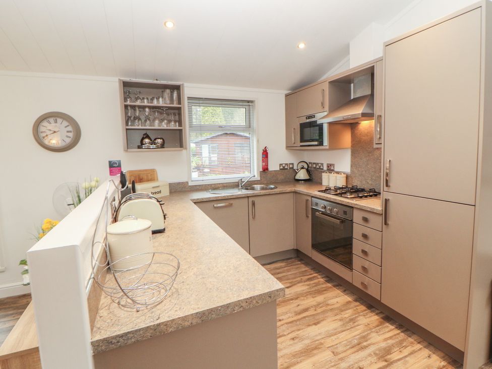 A kitchen with appliances and cabinets at Dovedale Lodge Bowness 70, White Cross Bay near Windermere