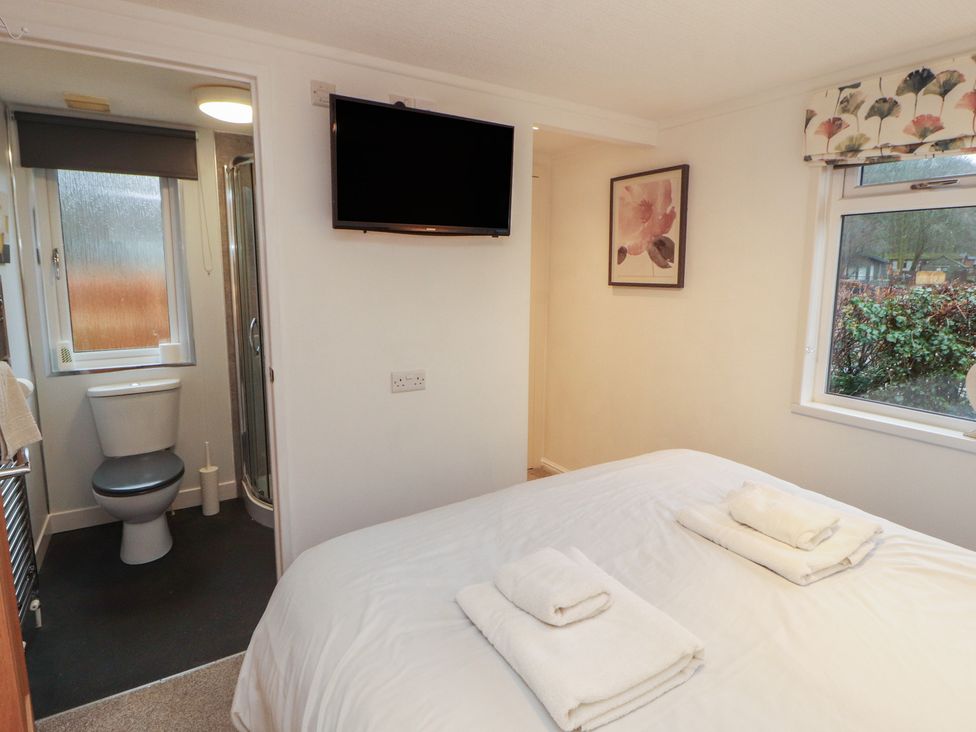 A bedroom with a bed and television at Dovedale Lodge in Bowness 70, White Cross Bay near Windermere
