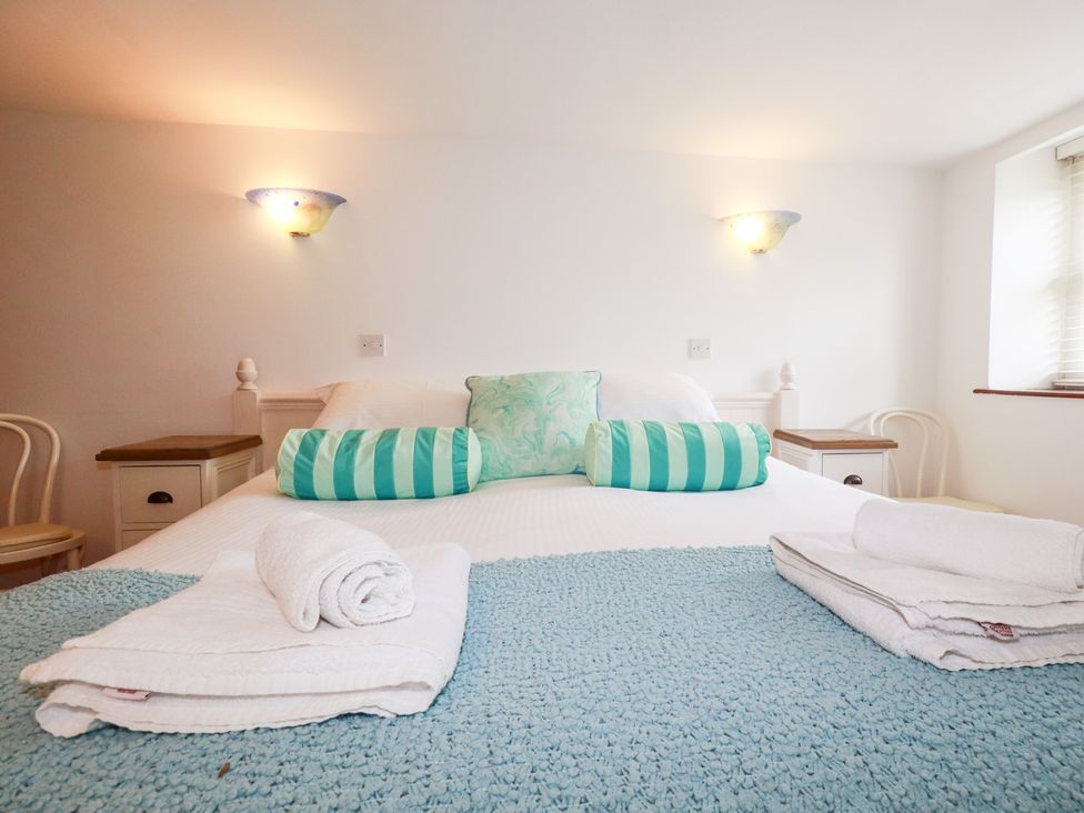 A bedroom with a bed and decorative pillows at Rosemaddon in Crantock