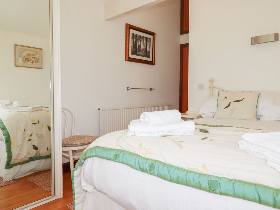 A bedroom with a bed and a chair at Rosemaddon in Crantock