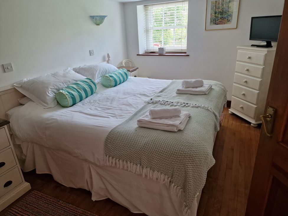 A bedroom with a double bed and a television at Rosemaddon in Crantock