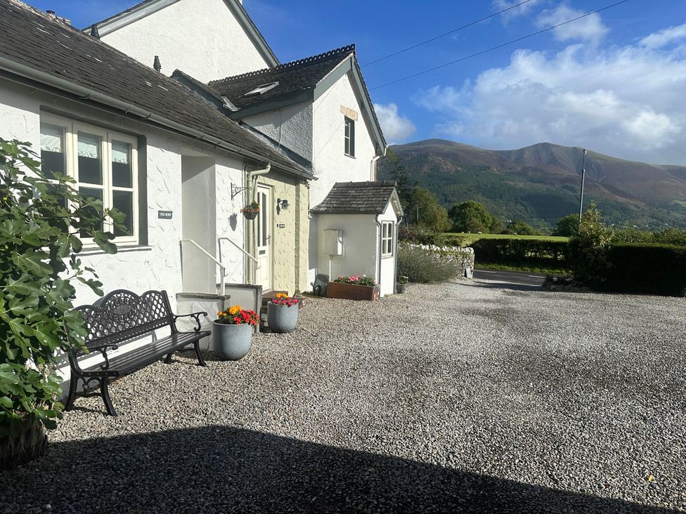 An outdoor view of a house with a bench and flower pots at Fox Howe in Thornthwaite