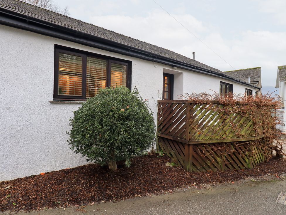 An exterior view of a building with a plant and fence at Jasmine Cottage in Thornthwaite