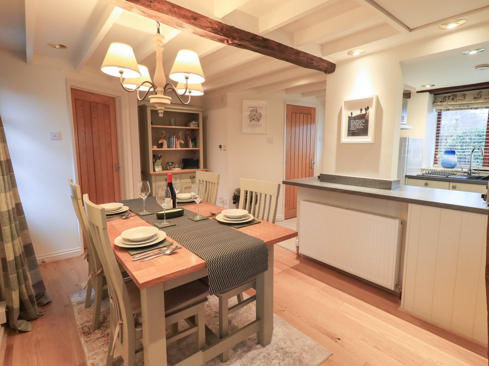 A dining room with a table set for dinner at Jasmine Cottage in Thornthwaite