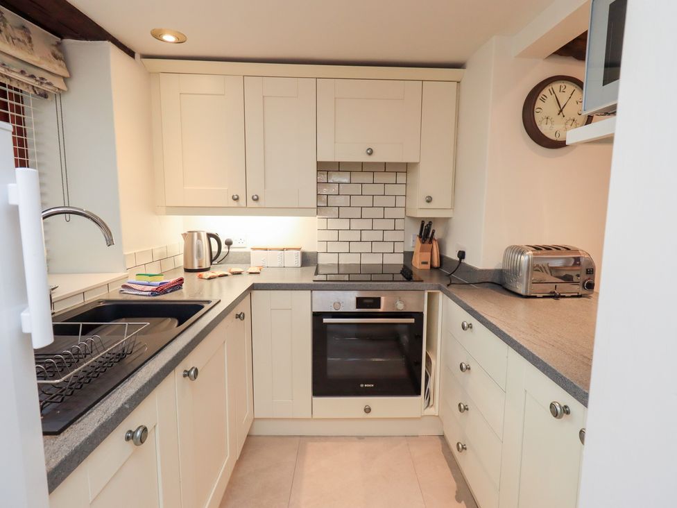 A kitchen with various appliances including an oven and toaster at Jasmine Cottage Thornthwaite