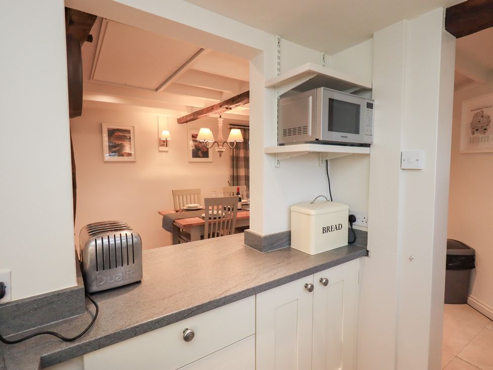 A kitchen featuring a toaster, microwave, and bread box at Jasmine Cottage in Thornthwaite