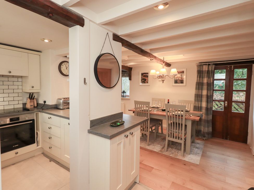 A kitchen with dining area and door at Jasmine Cottage Thornthwaite
