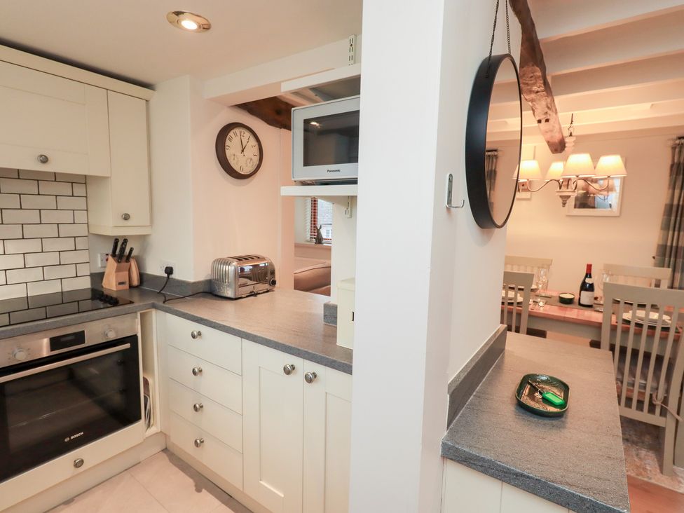 A kitchen with appliances and a dining area at Jasmine Cottage Thornthwaite