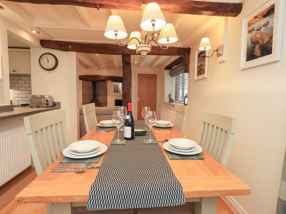 A dining room with a table set for dinner at Jasmine Cottage Thornthwaite