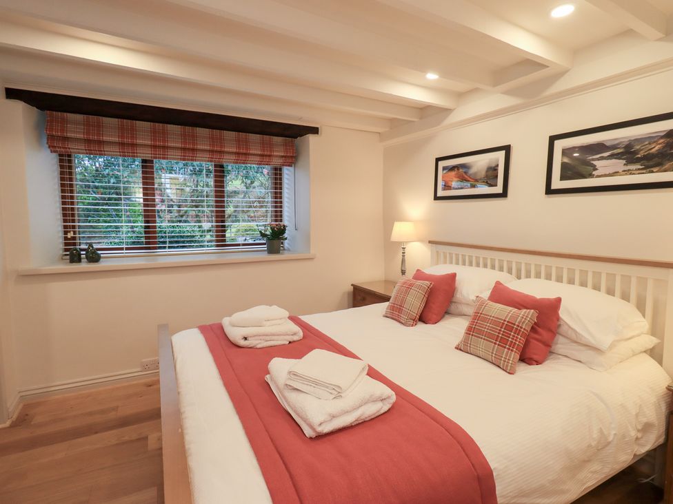 A bedroom with a double bed and window at Jasmine Cottage in Thornthwaite