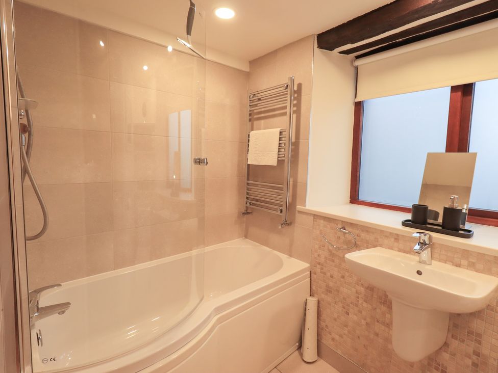 A bathroom with a bathtub and sink at Jasmine Cottage in Thornthwaite
