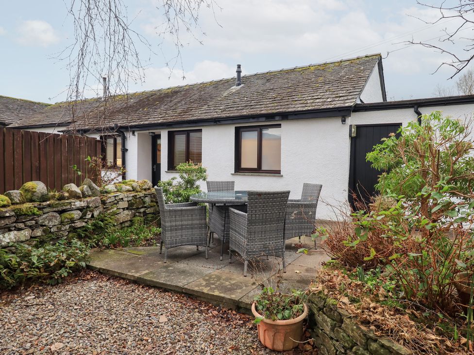 An outdoor seating area with a table and chairs at Jasmine Cottage in Thornthwaite