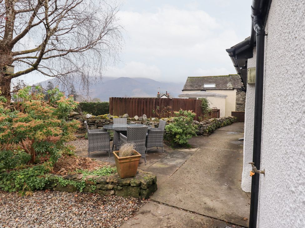 A garden with a table and chairs at Jasmine Cottage in Thornthwaite