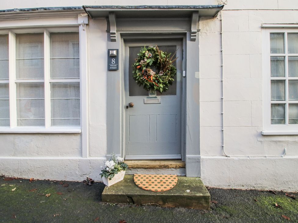 An entrance featuring a door with a wreath and doormat at 8 Welsh Street in Bishops Castle