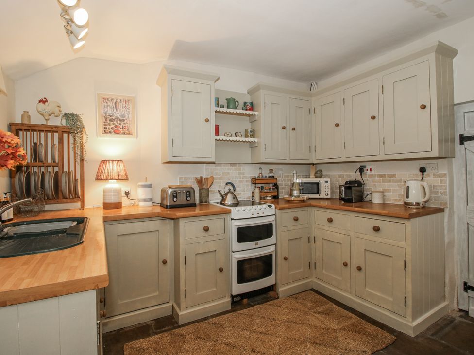 A kitchen with appliances and wooden countertops at 8 Welsh Street Bishops Castle