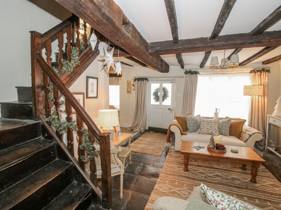 A living room with a staircase and seating area at 8 Welsh Street Bishops Castle