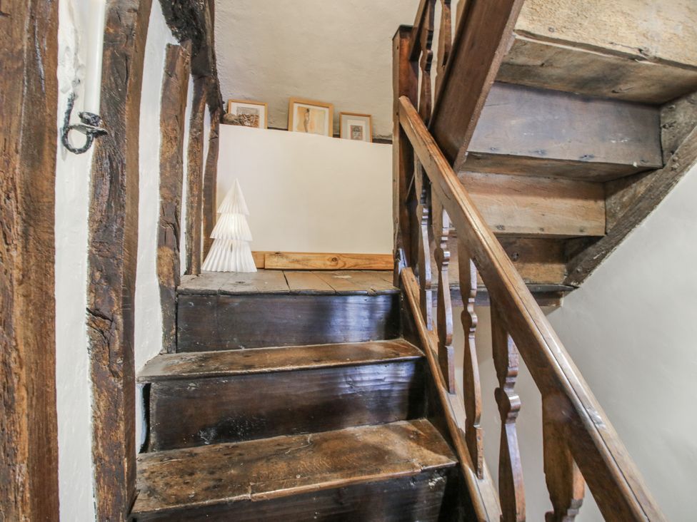 A staircase with wooden railing and decorative tree at 8 Welsh Street Bishops Castle