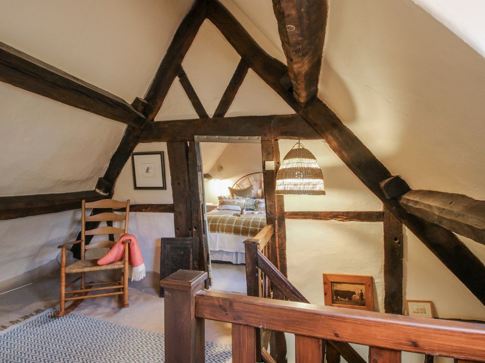 A bedroom with a chair and light fixture at 8 Welsh Street in Bishops Castle
