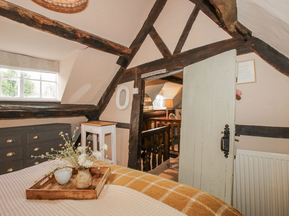 A bedroom with a window and a door leading to a hallway at 8 Welsh Street in Bishops Castle