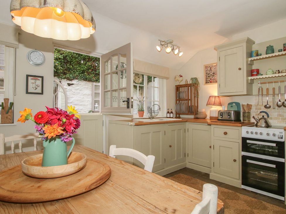 A kitchen with a table and flowers at 8 Welsh Street in Bishop's Castle
