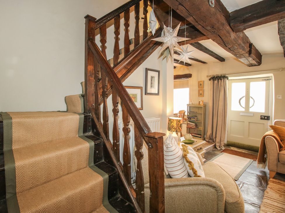A living room with stairway and door at 8 Welsh Street in Bishop's Castle