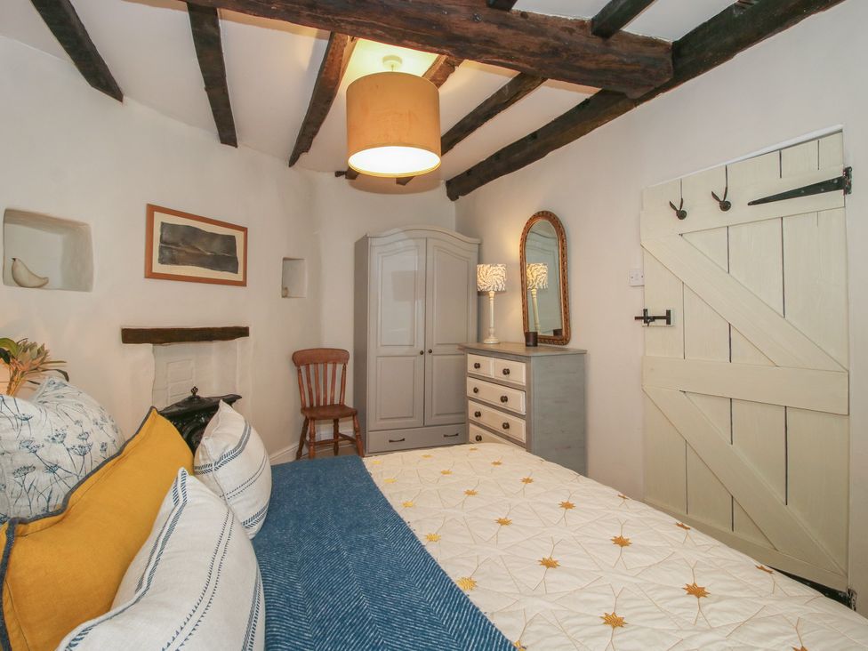 A bedroom with a bed, dresser, and wardrobe at 8 Welsh Street in Bishop's Castle