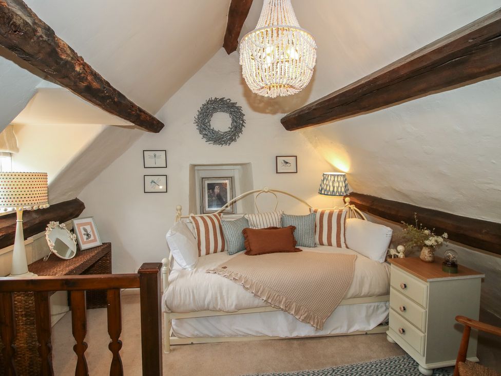 A bedroom with a bed and chandelier at 8 Welsh Street in Bishop's Castle