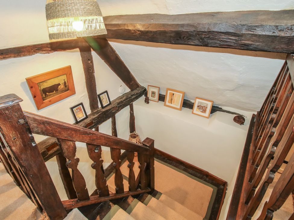 A hallway with stairs and wall art at 8 Welsh Street in Bishop's Castle