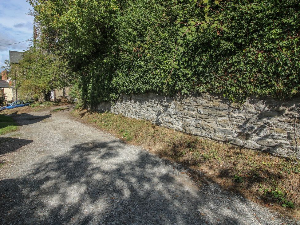A gravel path next to a stone wall and hedge at 8 Welsh Street in Bishop's Castle