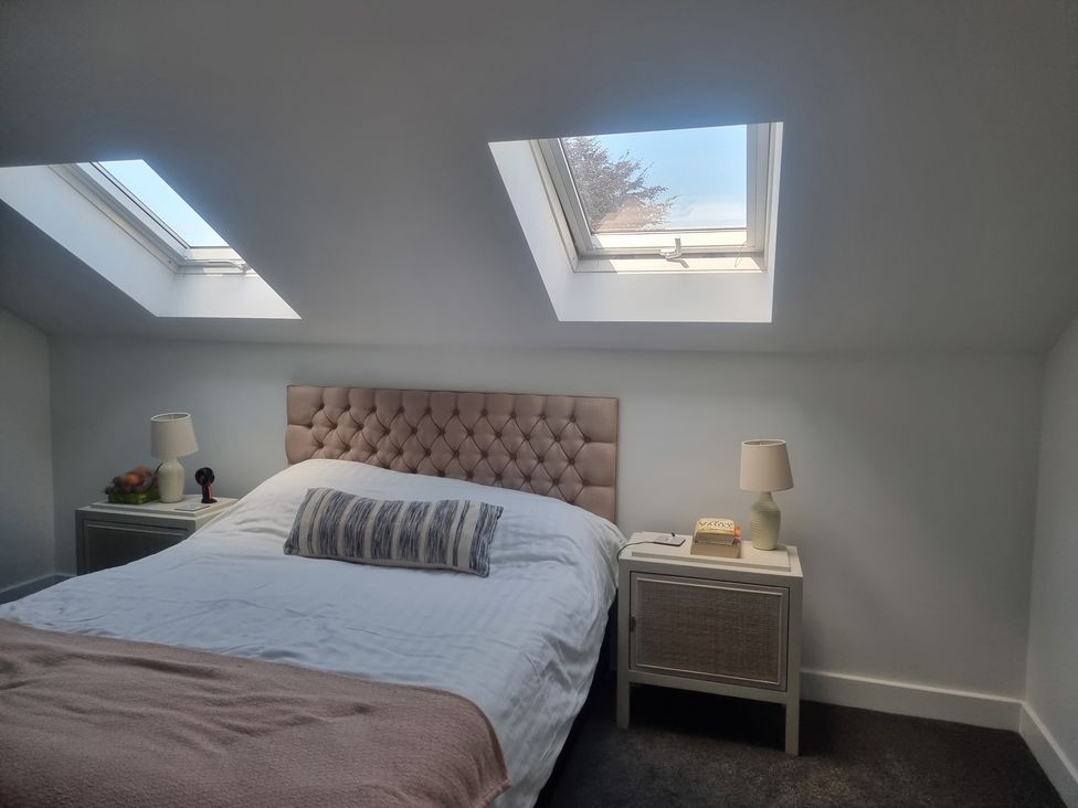 A bedroom with a bed and skylights at Edgemere Cottage in Cartmel