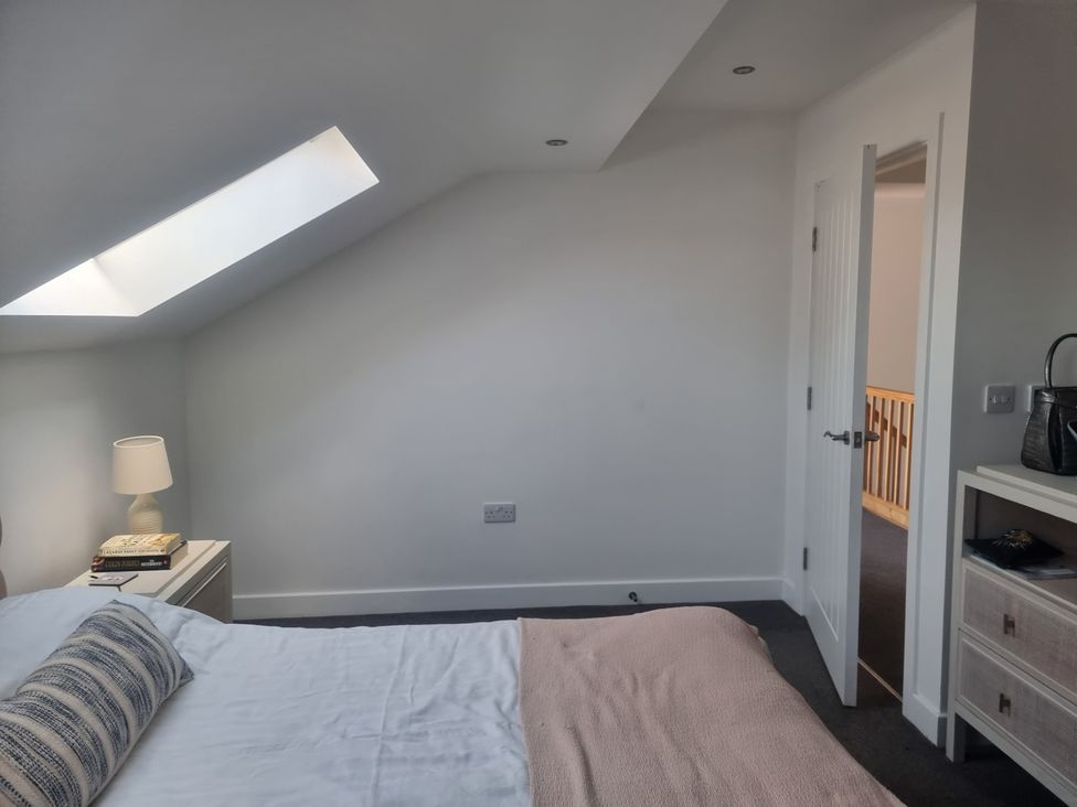 A bedroom with a bed and lamp at Edgemere Cottage in Cartmel