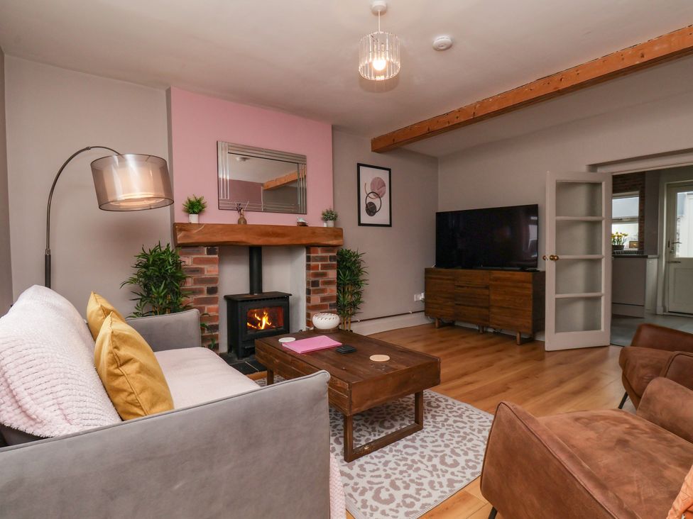A living room with a fireplace and television at 7 St. Germains Lane