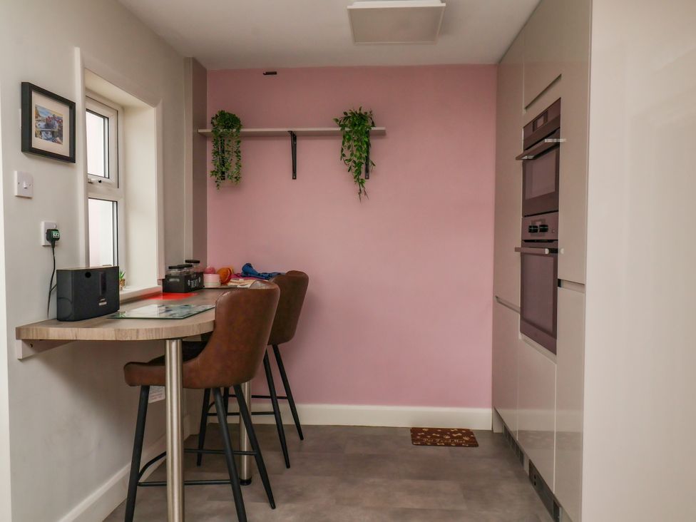 A kitchen with a table and stools at 7 St. Germains Lane