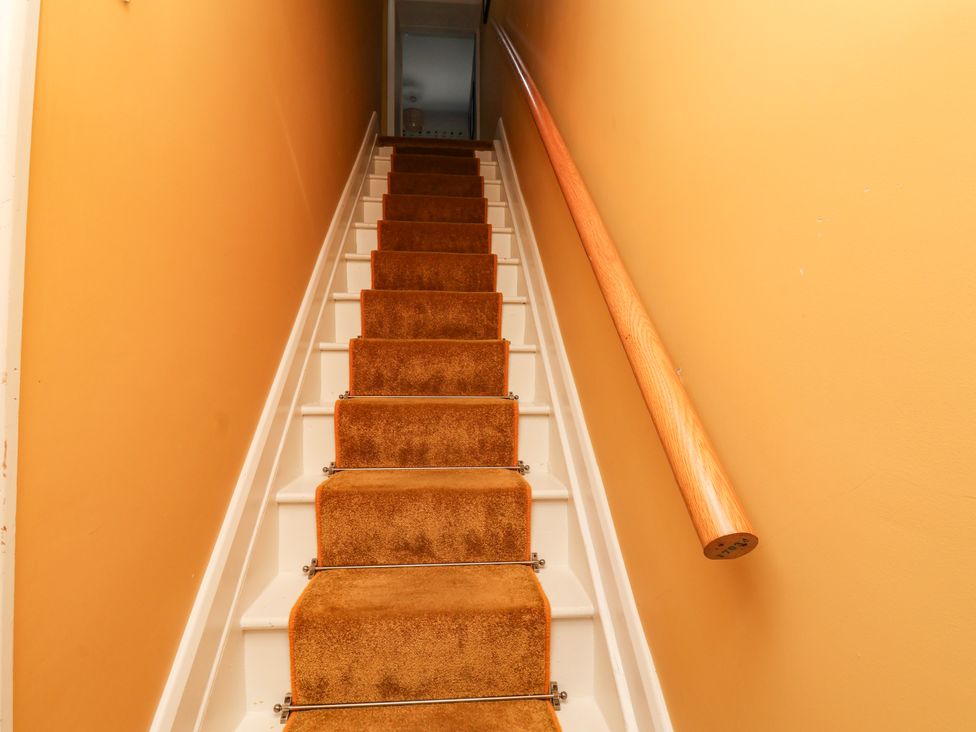 A staircase with carpeted steps and a wooden handrail at 7 St. Germains Lane