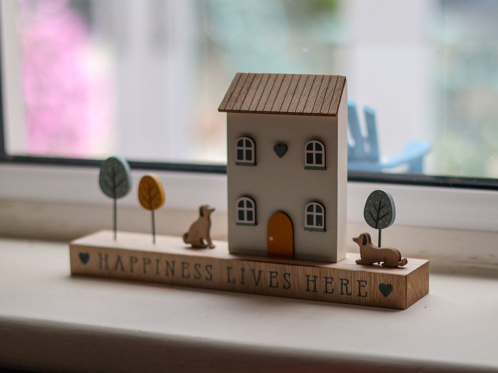 A decorative house and dog figurines on a windowsill at 7 St. Germains Lane