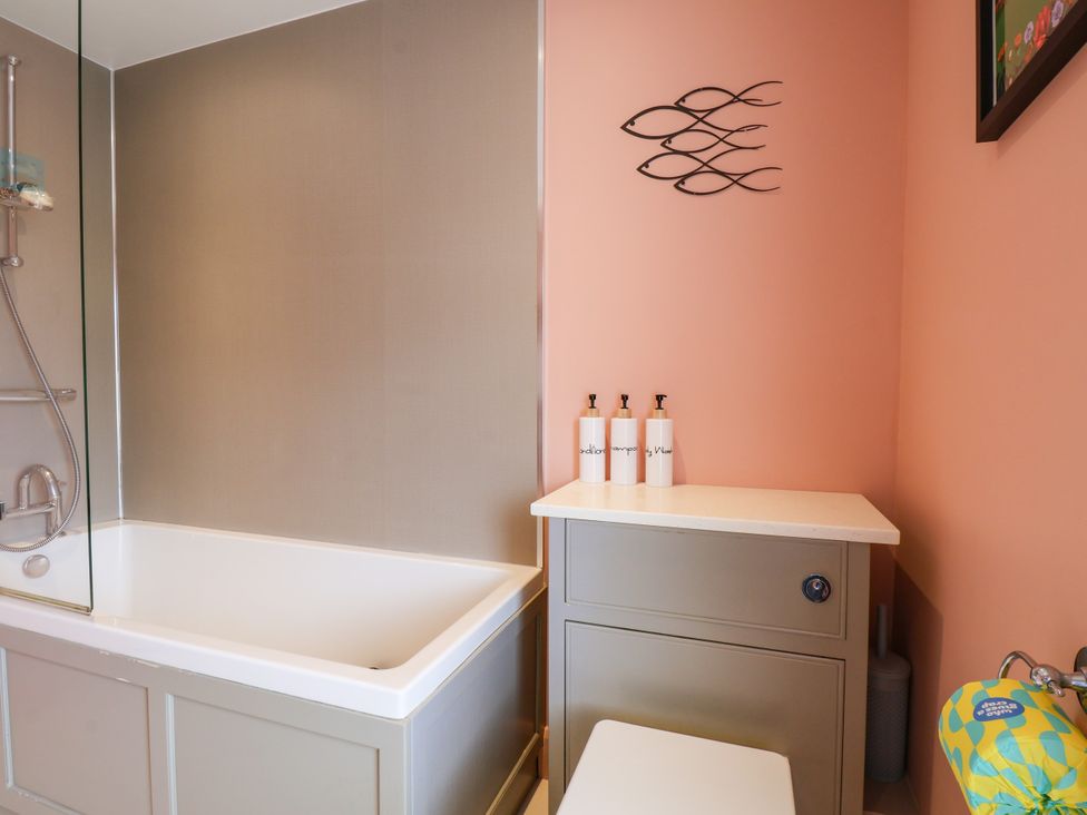 A bathroom with a bathtub and storage cabinet at 7 St. Germains Lane