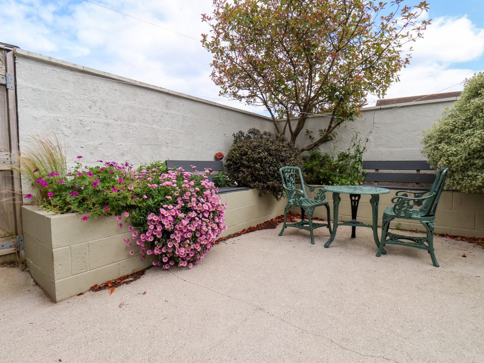 A garden with a table and chairs surrounded by flowers at 7 St. Germains Lane