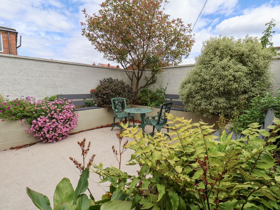 A garden with seating area and plants at 7 St. Germains Lane