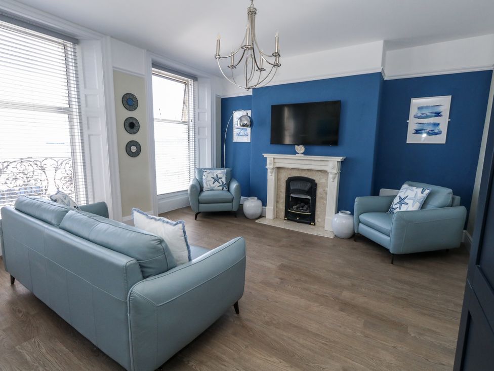 A living room with a television and seating at Apartment 1 in Weymouth