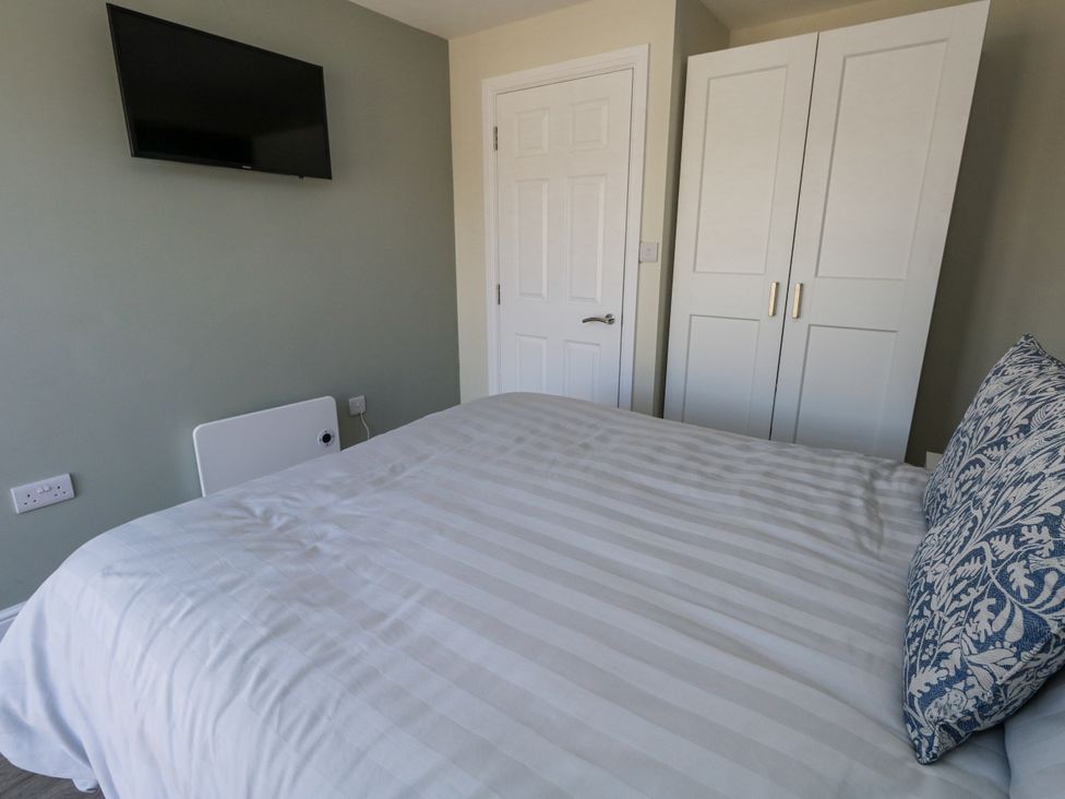 A bedroom with a bed and wardrobe at Apartment 1 in Weymouth
