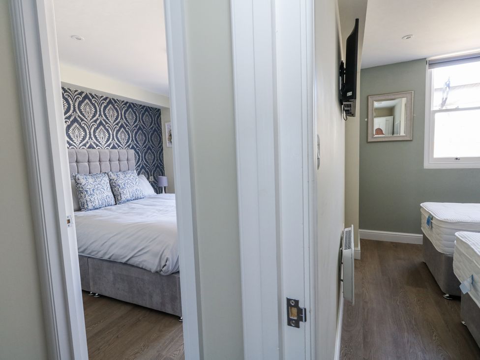 A bedroom with a bed and TV at Apartment 1 in Weymouth