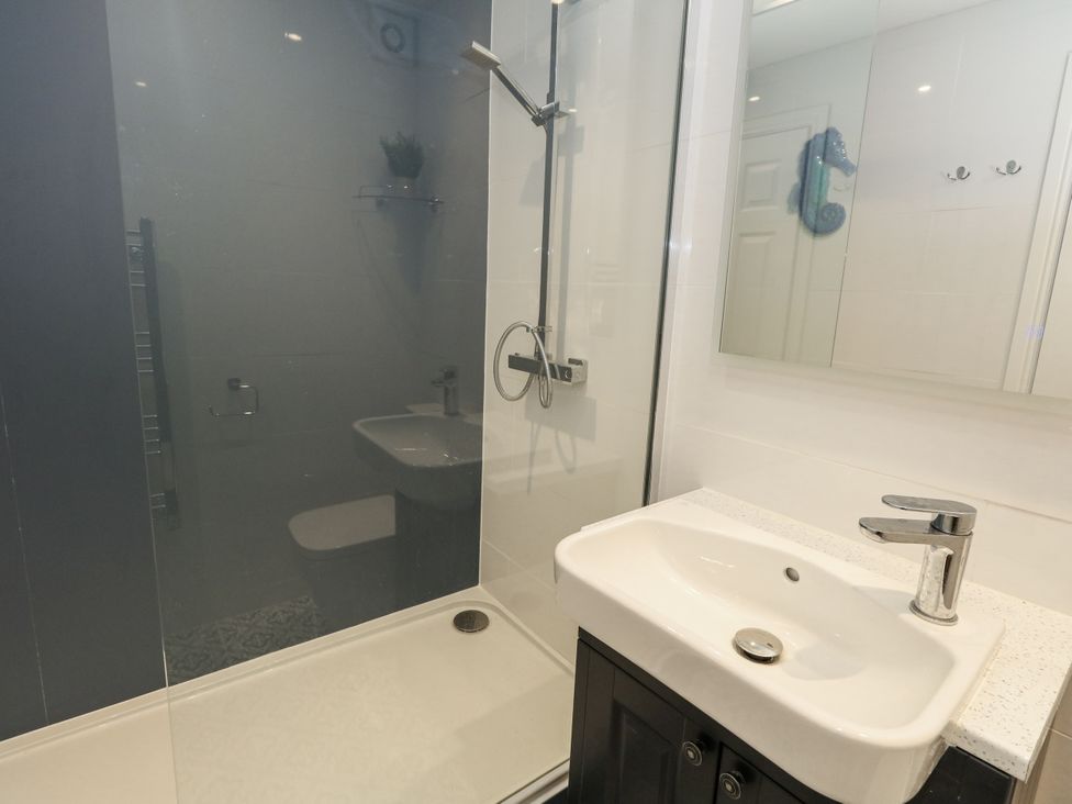 A bathroom with a shower and sink at Apartment 1 in Weymouth