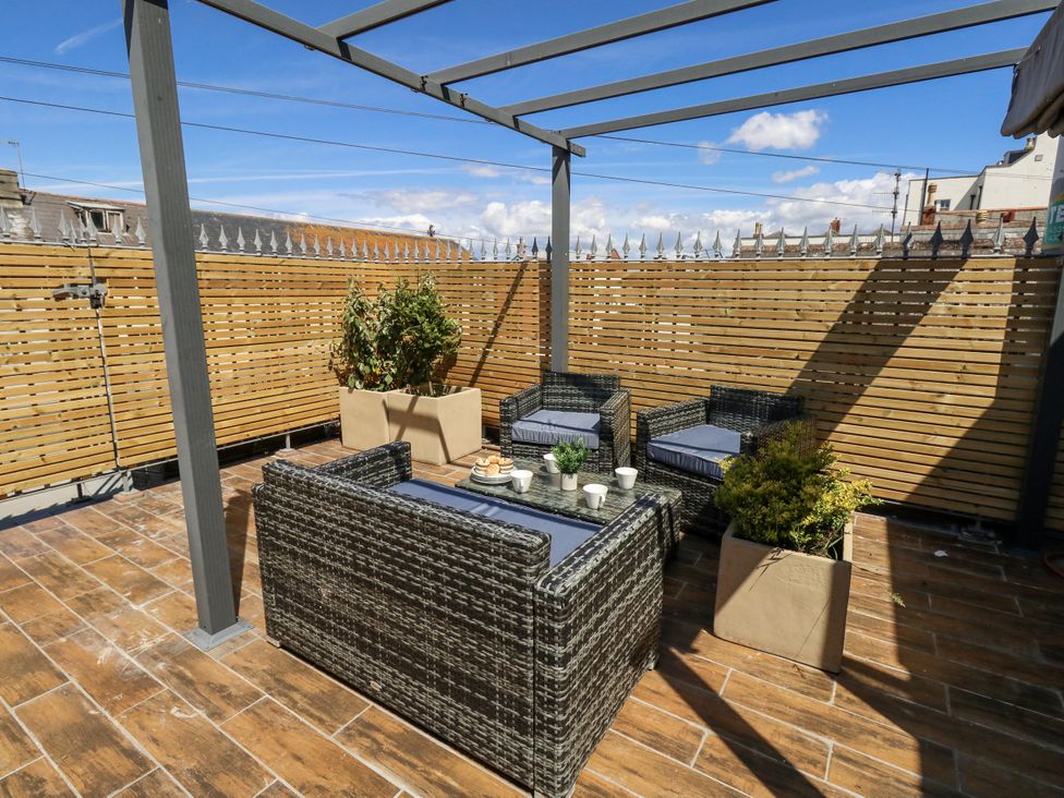 An outdoor terrace featuring seating and a table at Apartment 1 in Weymouth