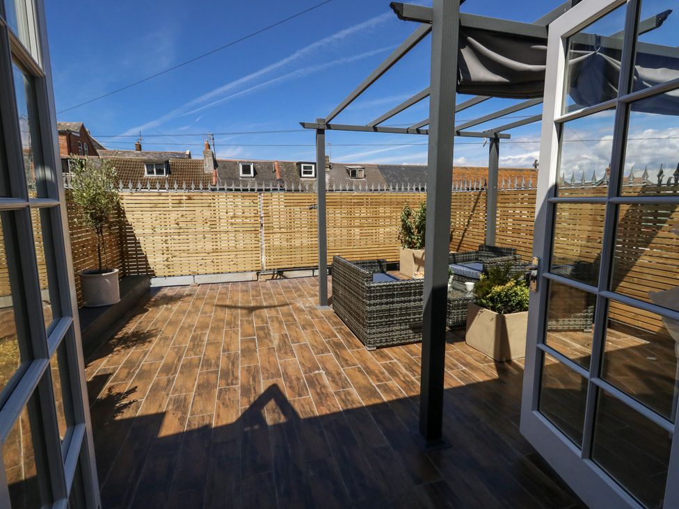 A terrace with outdoor seating and potted plants at Apartment 1 in Weymouth