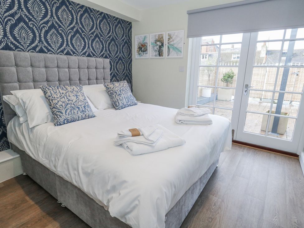 A bedroom with a bed and sliding door at Vista Mare 1 in Weymouth