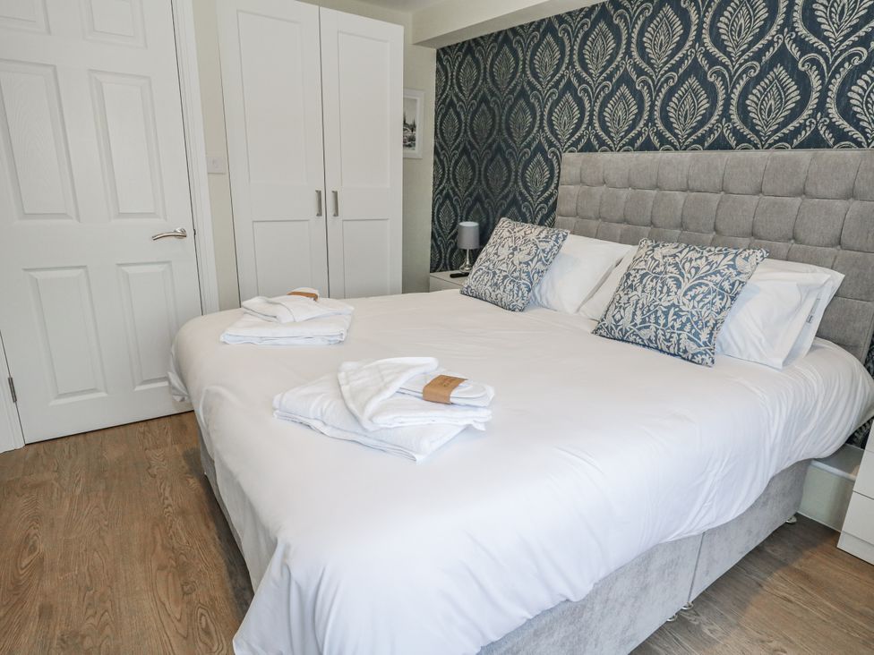 A bedroom with a bed and wardrobe at Vista Mare 1 Weymouth