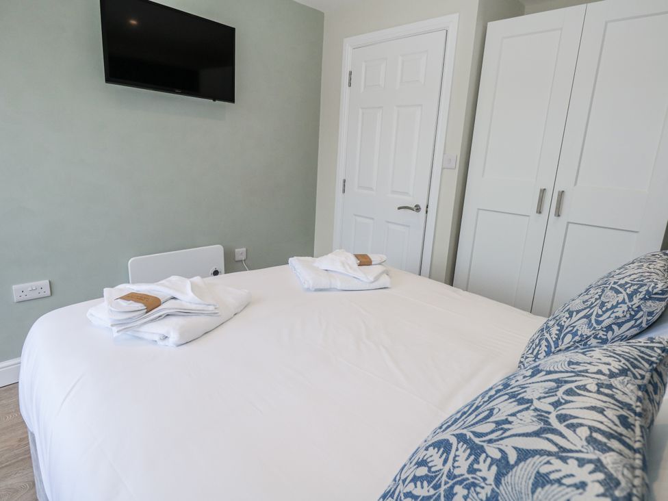 A bedroom with a bed and television at Vista Mare 1 Weymouth