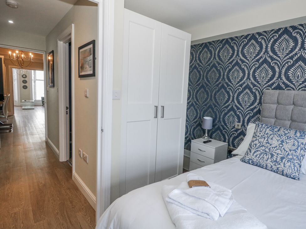A bedroom with a bed and wardrobe at Vista Mare 1 in Weymouth